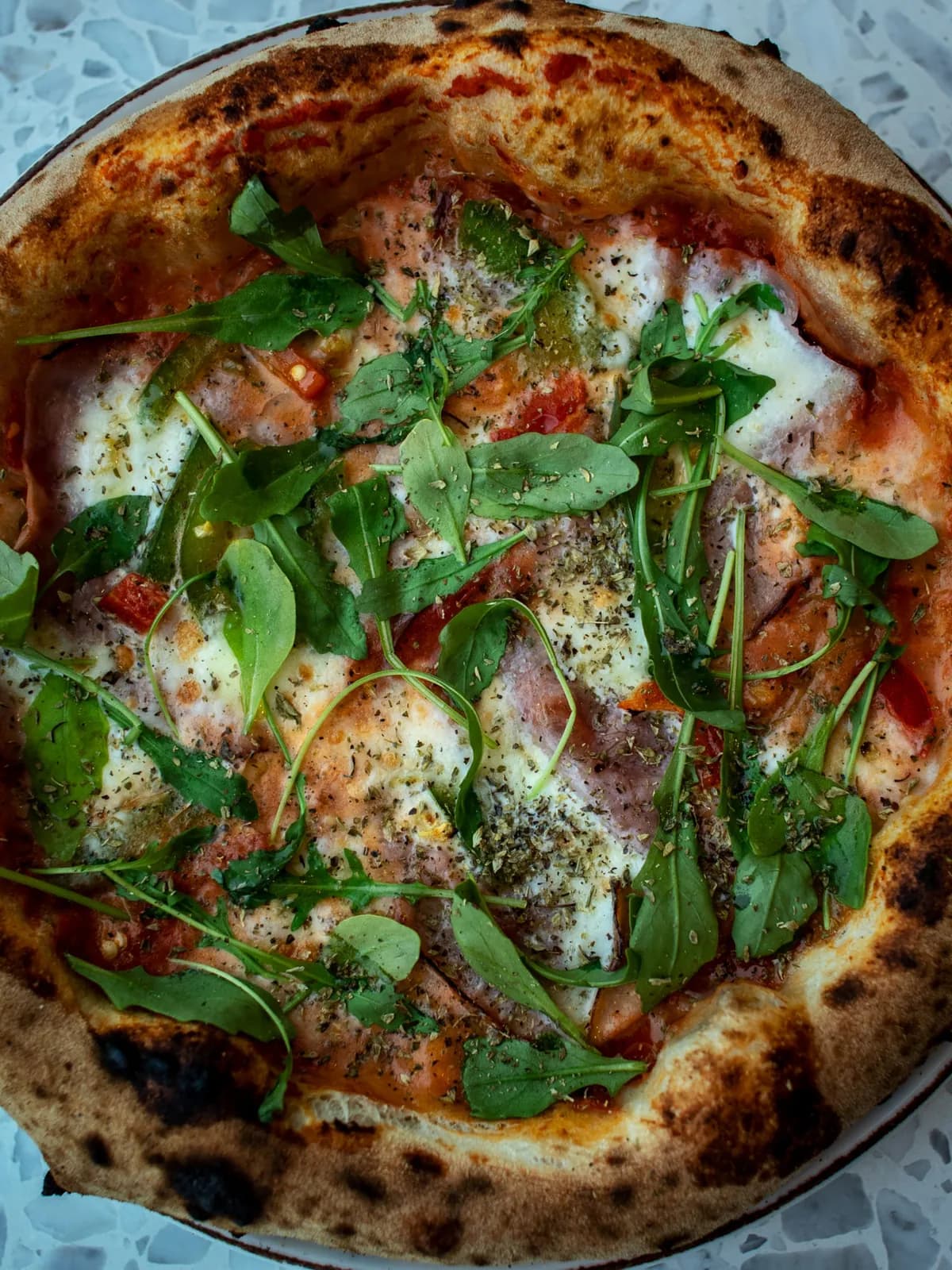 Stenugnsbakad pizza med ruccola och mozzarella, fotograferad uppifrån